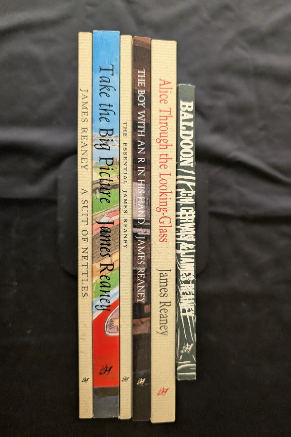 Stack of books by James Reaney on a dark fabric background