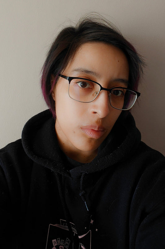 Maria Stengos wearing glasses and a black hoodie against a plain background.