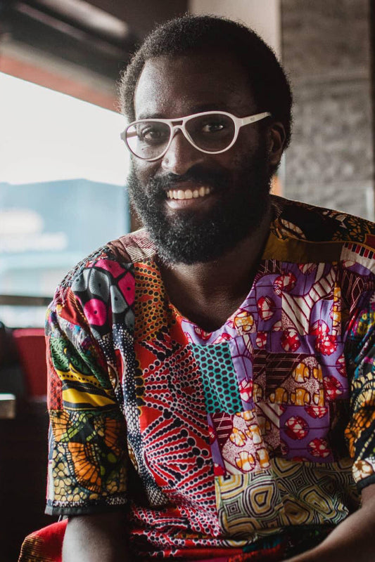 Man wearing a colorful patterned shirt with glasses indoors